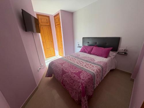 a small bedroom with a bed and a window at Encantador, tranquilo y centrico in Málaga