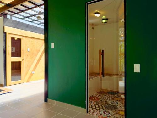 a green door in a bathroom with a shower at Ziatá in Simijaca
