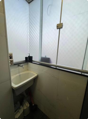 a bathroom with a sink and a mirror at AP FRENTE MAR Compacto, Completo e Confortável in São Vicente