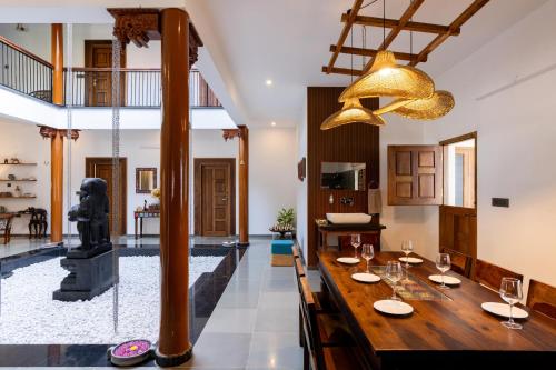 a dining room with a long table and a chandelier at 1st Miracle By Mirth, Mythadi , Coorg in Ammatti