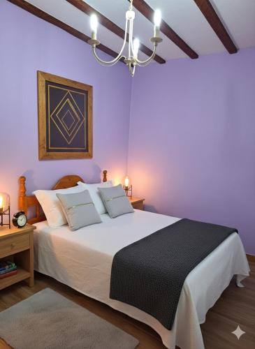 a bedroom with a large bed with purple walls at El Burby II in Somo