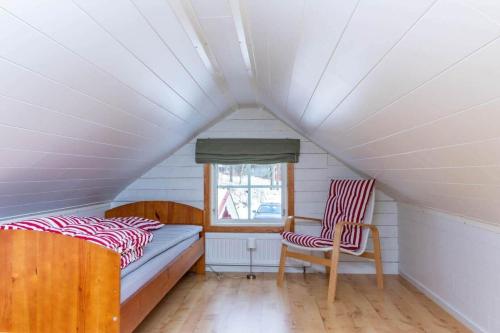 a bedroom with a bed and two chairs in a attic at VAR986-Rada-As-34 in Råda