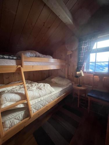 two bunk beds in a room with a window at The View - Mountain cabin with stunning views in Stranda