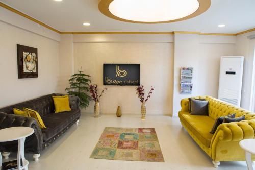 a living room with couches and a tv at Bilge Suite Hotel in Corum