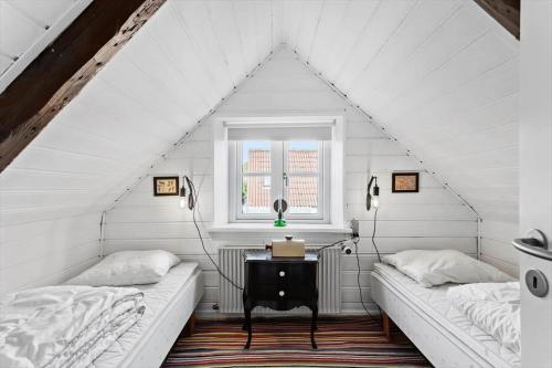 two beds in a white room with a window at AE315-Marstal-Kongensgade-8 in Marstal