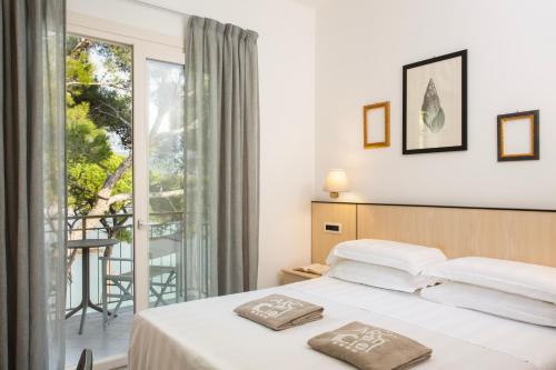 a hotel room with a bed and a balcony at Hotel Arc En Ciel in Diano Marina