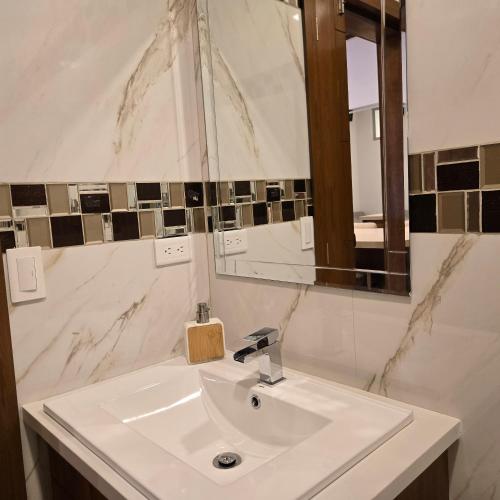 a bathroom with a white sink and a mirror at majesty beautiful suite in Cuenca
