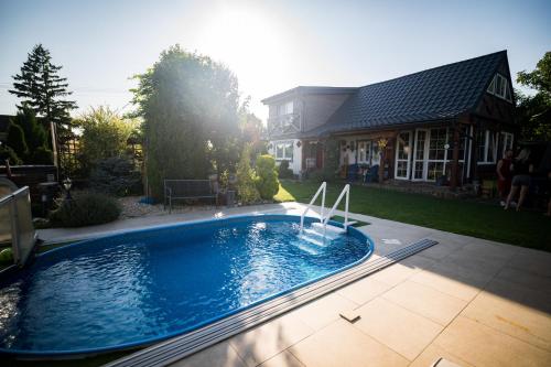 a swimming pool in front of a house at Drevenička Modruška in Malý Čepčín