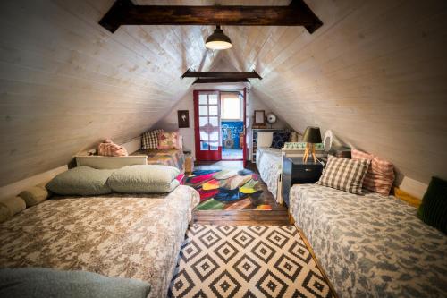 a room with two beds in a attic at Drevenička Modruška in Malý Čepčín