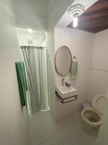 a bathroom with a toilet and a sink and a mirror at Apartamento central próximo à catedral com 2 quartos e 2 banheiros in Santo Ângelo