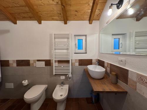 a bathroom with a white toilet and a sink at La Dimora Della Volpe in Calice Ligure