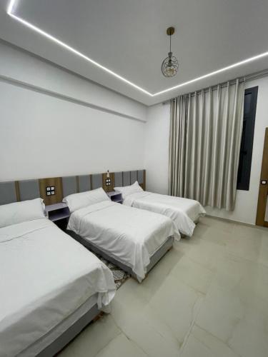 a room with three beds and a window at Hotel kairouan in Fez