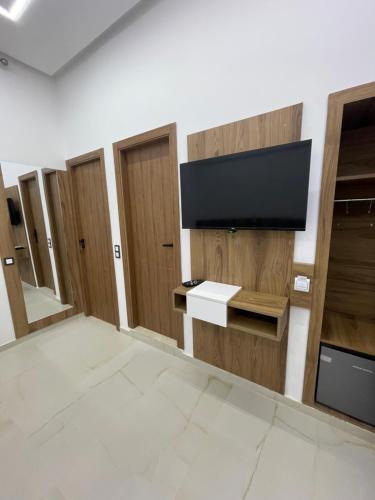a room with wooden doors and a flat screen tv at Hotel kairouan in Fez
