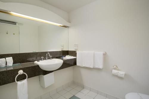 a white bathroom with a sink and a mirror at Tamar Valley Resort Grindelwald in Grindelwald