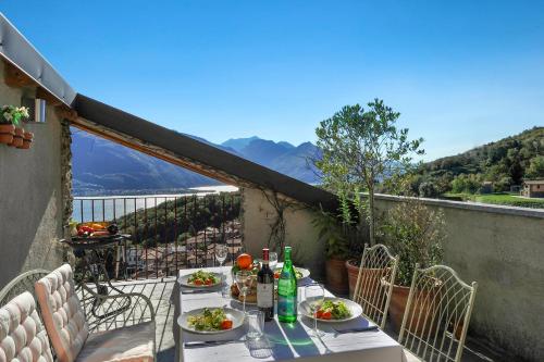 a table with plates of food on top of a balcony at Belmonte Terrazzo in Pianello Del Lario