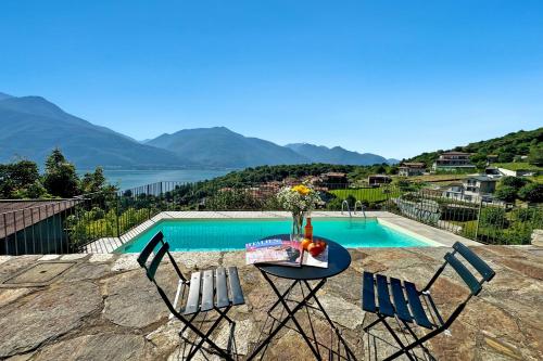 a table and chairs with a view of a swimming pool at Belmonte Terrazzo in Pianello Del Lario