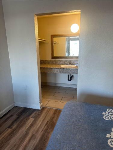 a bathroom with a sink and a mirror at Best Economy Inn & Suites in Bakersfield