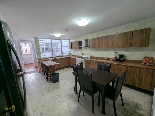 a kitchen with wooden cabinets and a table and chairs at Casa Amari - Para 17 Personas - Grupos y Eventos in Morelia