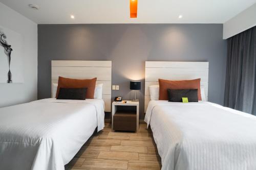 twee bedden die naast elkaar in een kamer staan bij Real Inn Perinorte in Mexico-Stad