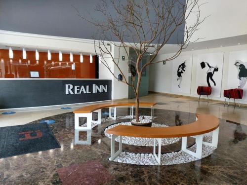 een tafel met een boom in het midden van een kamer bij Real Inn Perinorte in Mexico-Stad