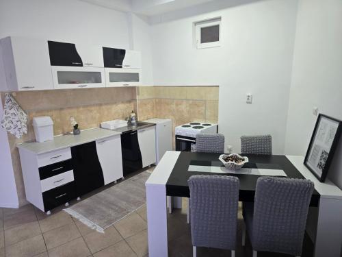 a kitchen with a table and some chairs and a sink at Iskra Apartment 2 in Kragujevac