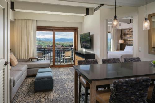 a living room with a couch and a room with a view at Sheraton Steamboat Resort Villas in Steamboat Springs