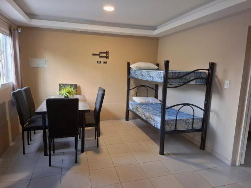 a dining room with a table and bunk beds at Oasis Pueyrredón in Rodeo del Medio