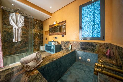 a bathroom with a large tub and a shower at Villa Maloulou in Marrakesh