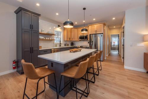 a kitchen with a large island with bar stools at Afterglow by Railey Vacations in Oakland