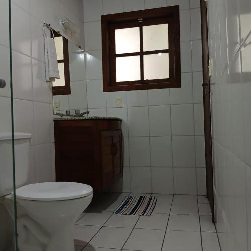 a bathroom with a toilet and a sink and a window at Casa Da MAELA in Corumbau
