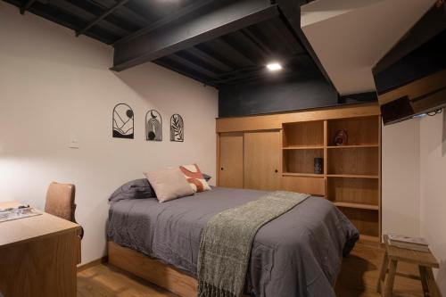 a bedroom with a bed and a desk in it at Lofts La Paz in Guadalajara