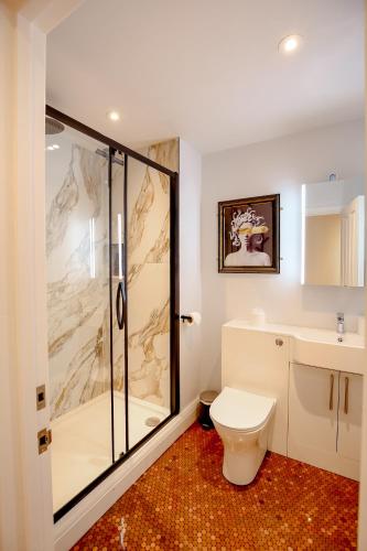a bathroom with a shower and a toilet and a sink at The Simms Suite in Worthing