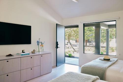 a bedroom with a flat screen tv and a bed at Three Ducks in Westhampton