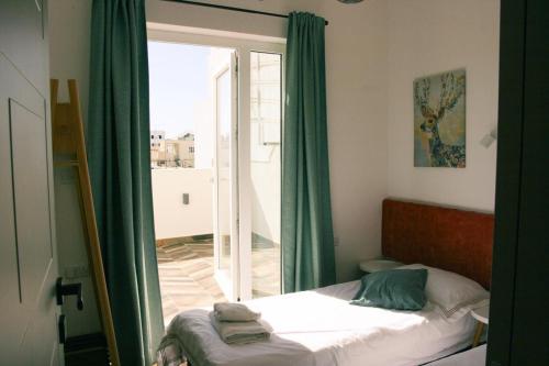 a bedroom with a bed and a sliding glass door at Two bedroom loft apartment with outdoor area, served with lift in Rabat