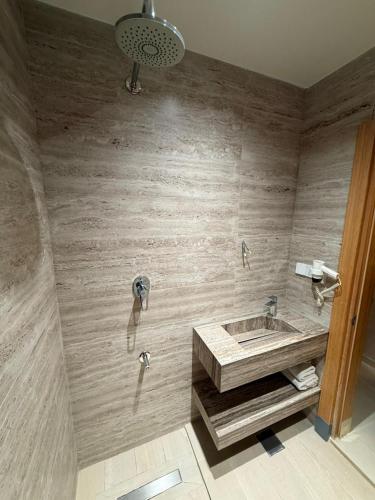 a bathroom with a sink and a wooden wall at Jawaher hotel in Karbala