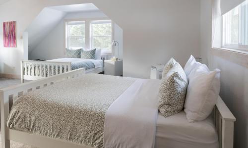 a white bedroom with a bed and a crib at Fieldstone Guesthouse in Clearwater