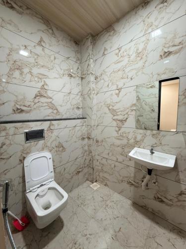 a bathroom with a toilet and a sink at Hotel Shivlok Inn in Ujjain