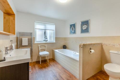 a bathroom with a tub and a toilet and a sink at 2 Bed in Bamburgh oc-gd1273 in Bamburgh