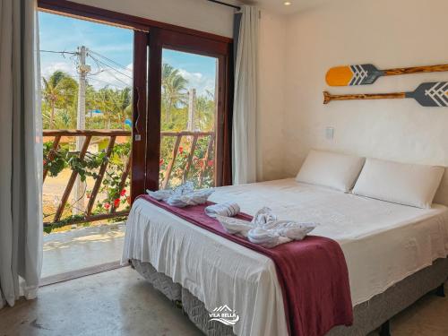 a bedroom with a bed and a balcony with a view at Pousada Vila Bella Icaraí in Icaraí