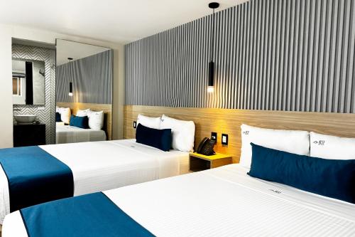 a hotel room with two beds and a telephone at Rest Inn Baja in Ensenada