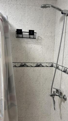 a bathroom with a shower with two shelves on the wall at Apartamento Caminho da Praia in Pedro Miguel