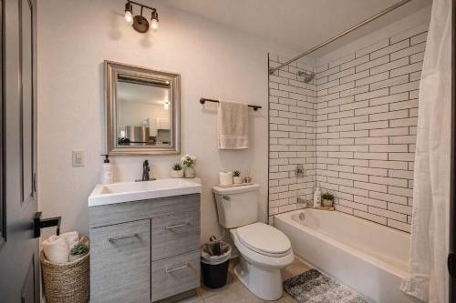 a bathroom with a sink and a toilet and a bath tub at Amazing Studio McKinley Beach - Brady St Lowr East in Milwaukee