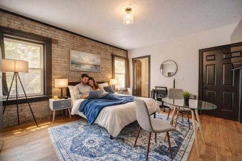 a man and woman laying on a bed with a laptop at Amazing Studio McKinley Beach - Brady St Lowr East in Milwaukee