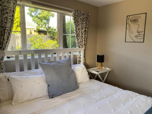 a bedroom with a white bed and a window at The Ground Floor Guest Suite in Dunedin