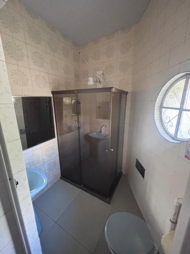 a bathroom with a shower with a toilet and a sink at Pousada Mara Mar Niterói in Niterói