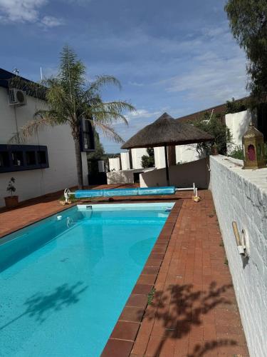 une piscine avec une allée en briques à côté d'une maison dans l'établissement Perfect, à Windhoek