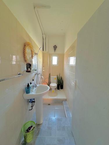 a bathroom with a sink and a toilet at Farissi's Zawya Surf House in Aourir