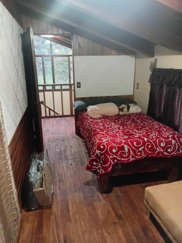 a bedroom with a bed with a red blanket at Cabaña lagunita in Sabinas