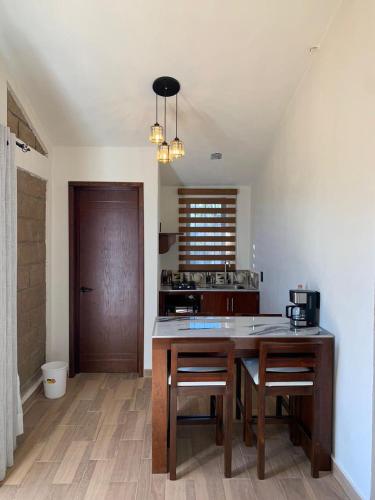 a kitchen with a table with chairs and a counter top at Cabañas Hacienda Real in Zacatlán