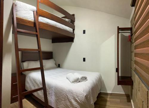 a bedroom with two bunk beds and a ladder at Cabañas Hacienda Real in Zacatlán